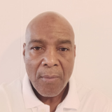 Headshot of Christopher Carpenter, looking at the camera with a neutral expression. He is wearing a light-colored polo shirt.